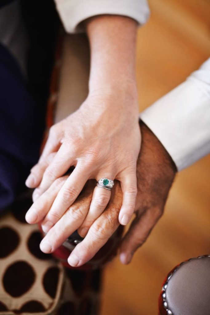 Closeup of a senior couple holding hands lovingly
